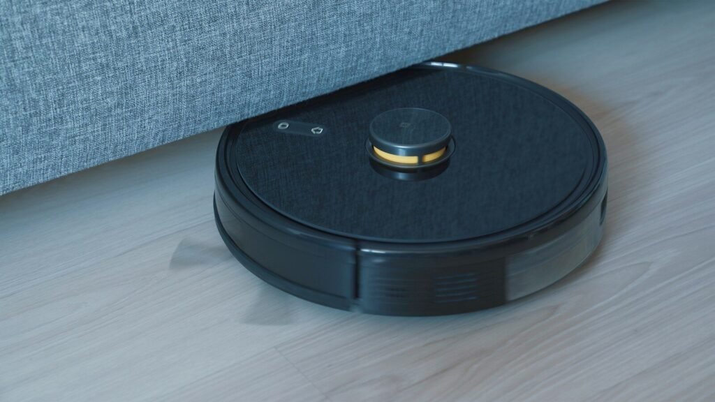 Black robot vacuum cleaner on a wooden floor, illustrating a robot vacuum buying comparison guide